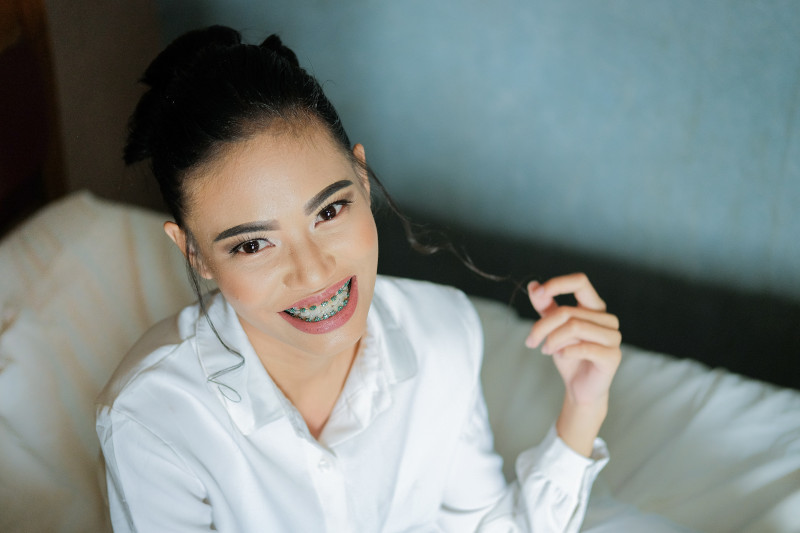 A young woman with braces smiling.